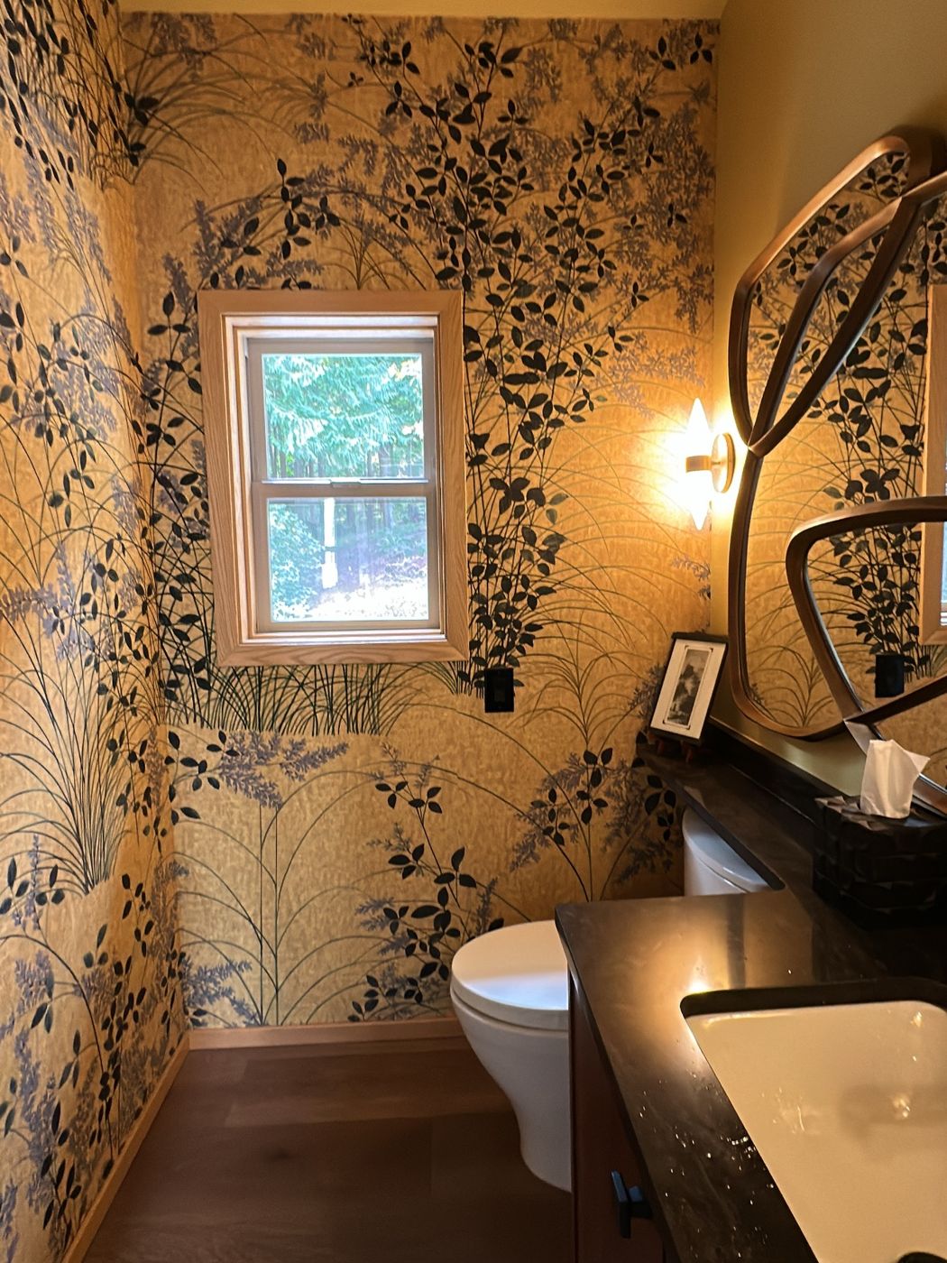 Powder room with dark botanical wallpaper on a gold ground