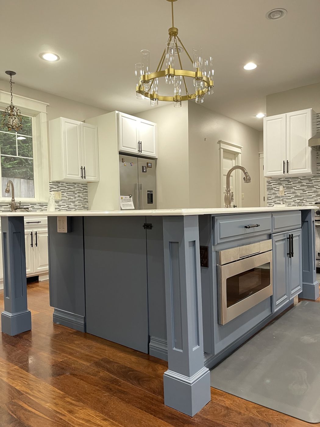 Kitchen with blue-grey painted island and white cabinets